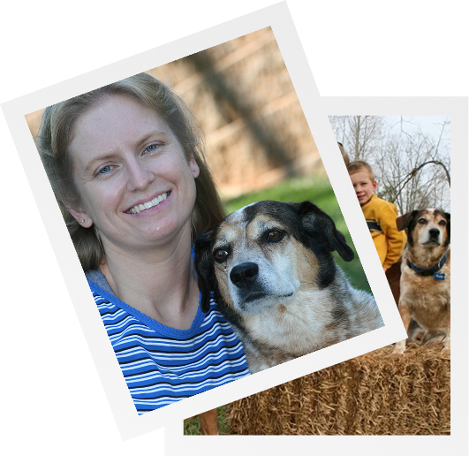 A woman smiles while sitting on the grass with her dog, enjoying a sunny day together.